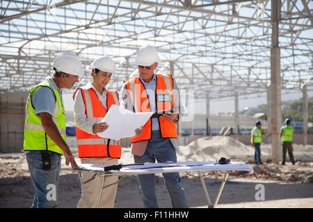 Architects reading blueprints at construction site Stock Photo