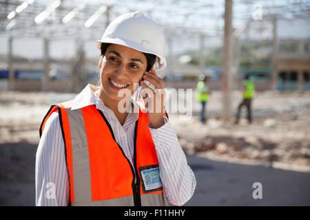 Architect talking on cell phone at construction site Stock Photo