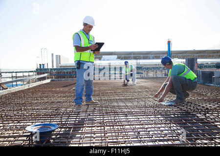 Construction workers arranging rebar at construction site Stock Photo