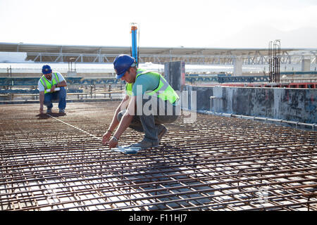 Construction workers arranging rebar at construction site Stock Photo