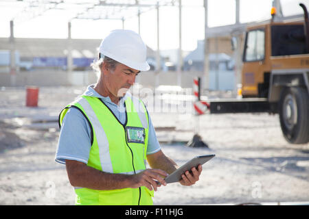 Caucasian construction worker using digital tablet at construction site Stock Photo