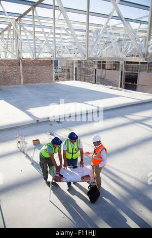 Architects reading blueprints at construction site Stock Photo