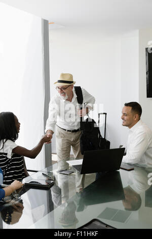 Businessman greeting colleagues in office meeting Stock Photo