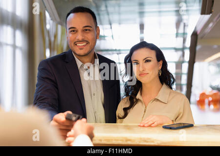 Business people checking into hotel with concierge Stock Photo