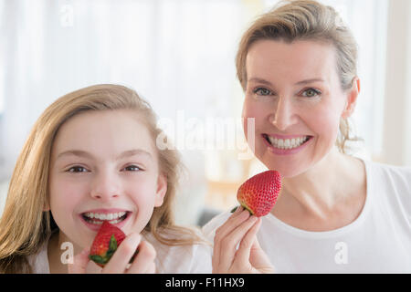 Caucasian mother and daughter eating strawberries Stock Photo