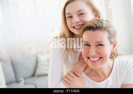 Caucasian mother and daughter smiling in living room Stock Photo