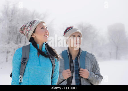Couple hiking in snowy field Stock Photo