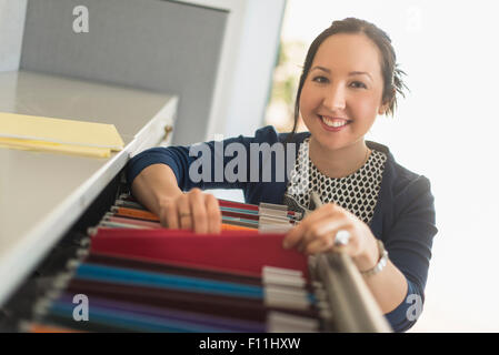 Mixed race businesswoman choosing files in office Stock Photo