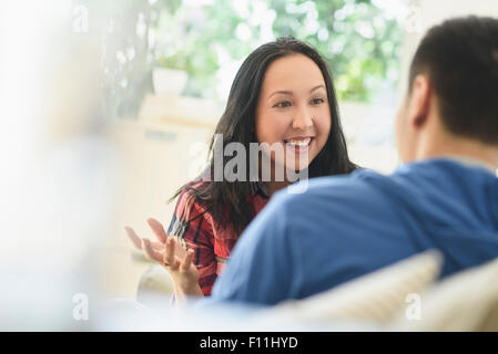 Couple talking on sofa in living room Stock Photo