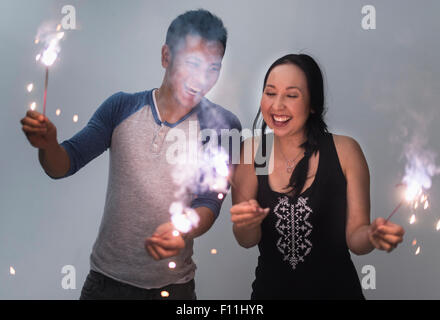 Smiling couple playing with sparklers Stock Photo