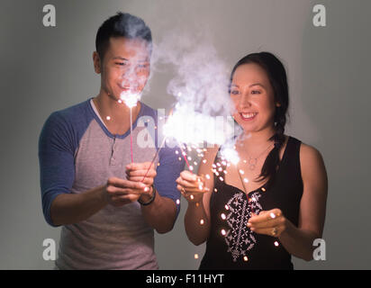 Smiling couple playing with sparklers Stock Photo