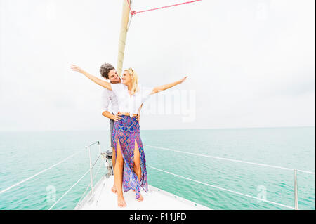 Couple standing on deck of sailboat Stock Photo