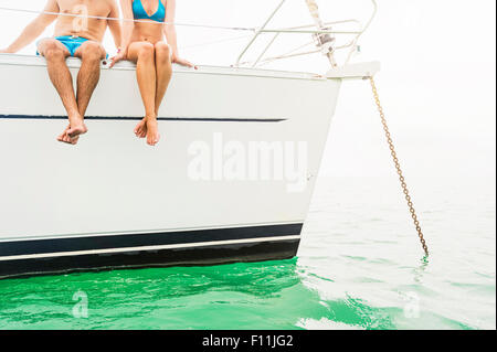 Couple sitting on deck of sailboat Stock Photo