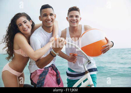Smiling friends hugging on beach Stock Photo