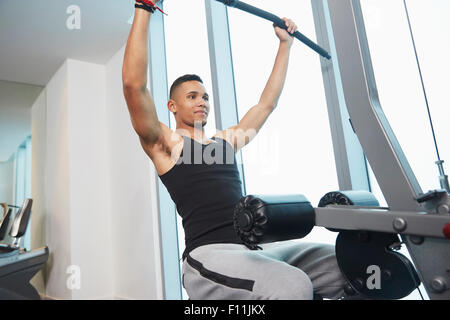 Black man using exercise machine in gym Stock Photo