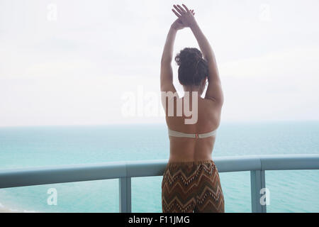 Mixed race woman overlooking ocean from balcony Stock Photo