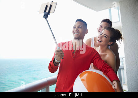 Smiling friends taking selfie on balcony Stock Photo