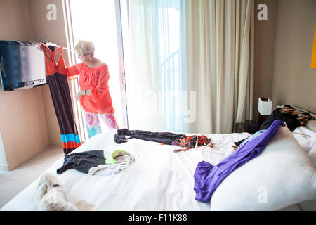 Older Caucasian woman choosing outfit in bedroom Stock Photo