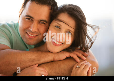 Close up of smiling Hispanic couple hugging Stock Photo