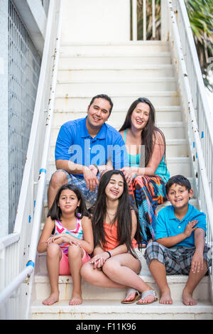 Hispanic family smiling on staircase Stock Photo