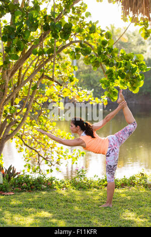 Hispanic woman practicing yoga in park Stock Photo