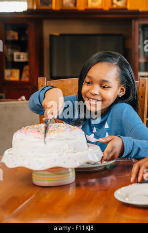 Black girl cutting cake at birthday party Stock Photo