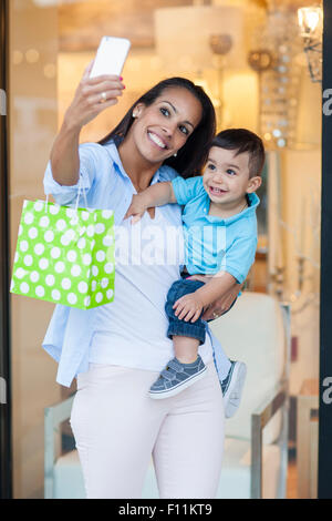 Hispanic mother and son taking selfies and shopping Stock Photo