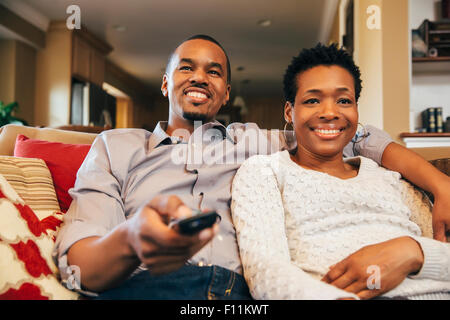 Black couple watching television on sofa Stock Photo