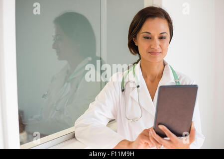 Mixed race doctor using digital tablet Stock Photo