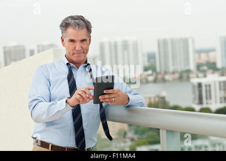 Caucasian businessman using digital tablet on balcony Stock Photo