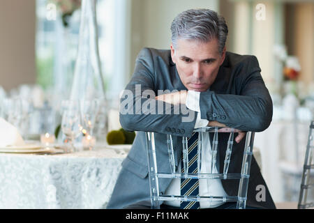 Caucasian businessman brooding in empty dining room Stock Photo
