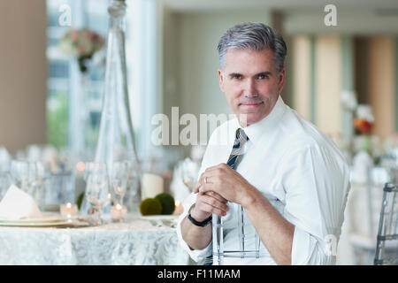Caucasian businessman smiling in empty dining room Stock Photo