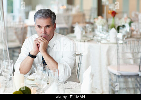 Caucasian businessman sitting in empty dining room Stock Photo