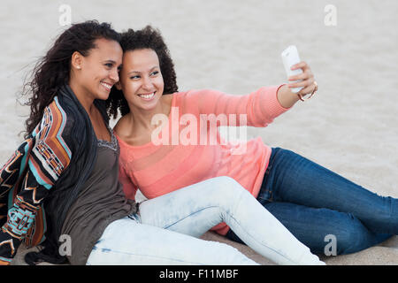 Women taking selfies on beach Stock Photo