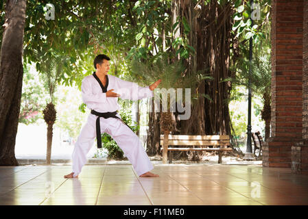 Hispanic man practicing martial arts on patio Stock Photo