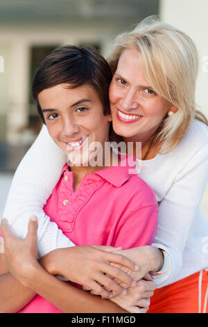 Smiling mother and son hugging outdoors Stock Photo