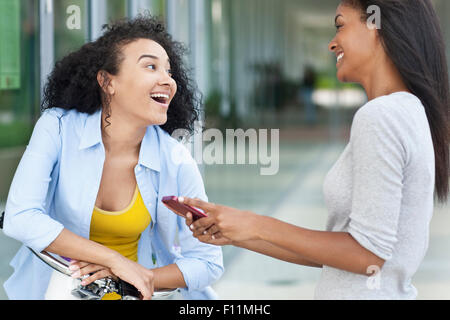 Black women talking on sidewalk Stock Photo