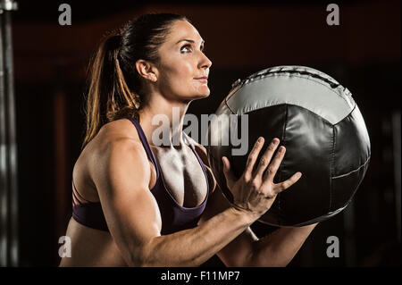 Caucasian athlete lifting resistance ball in gym