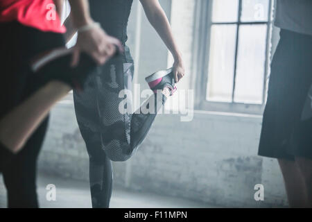 Athletes stretching legs in gym Stock Photo