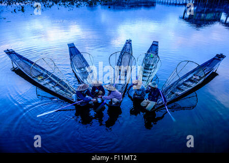 High angle view of Asian fishermen fishing in canoes on river