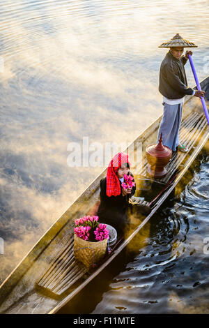Asian farmer and daughter rowing in canoe on river Stock Photo