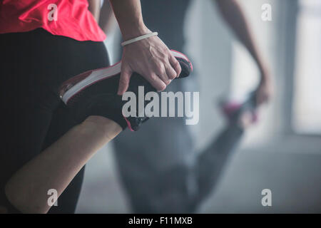 Athletes stretching legs in gym Stock Photo