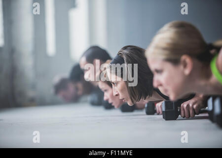Athletes doing push-ups and lifting weights on floor