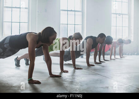 Athletes doing push-ups in gym Stock Photo