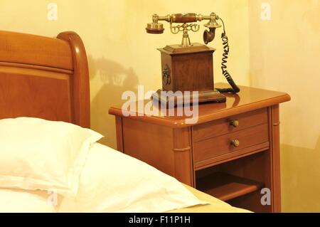 Detail of telephone by the bed in vintage bedroom Stock Photo