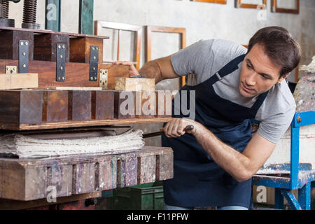 Worker Using Paper Press Machine In Factory Stock Photo