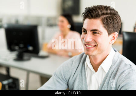 Young handsome man studying information technology in a classroom and smiling Stock Photo