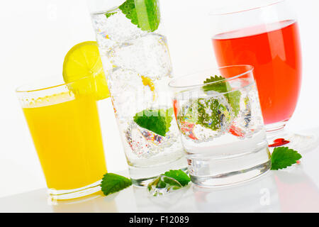 Glasses of water and fruit juices with mint and ice Stock Photo