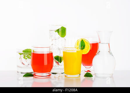 Glasses of water and fruit juices with mint and ice Stock Photo