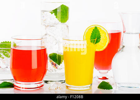 Glasses of water and fruit juices with mint and ice Stock Photo